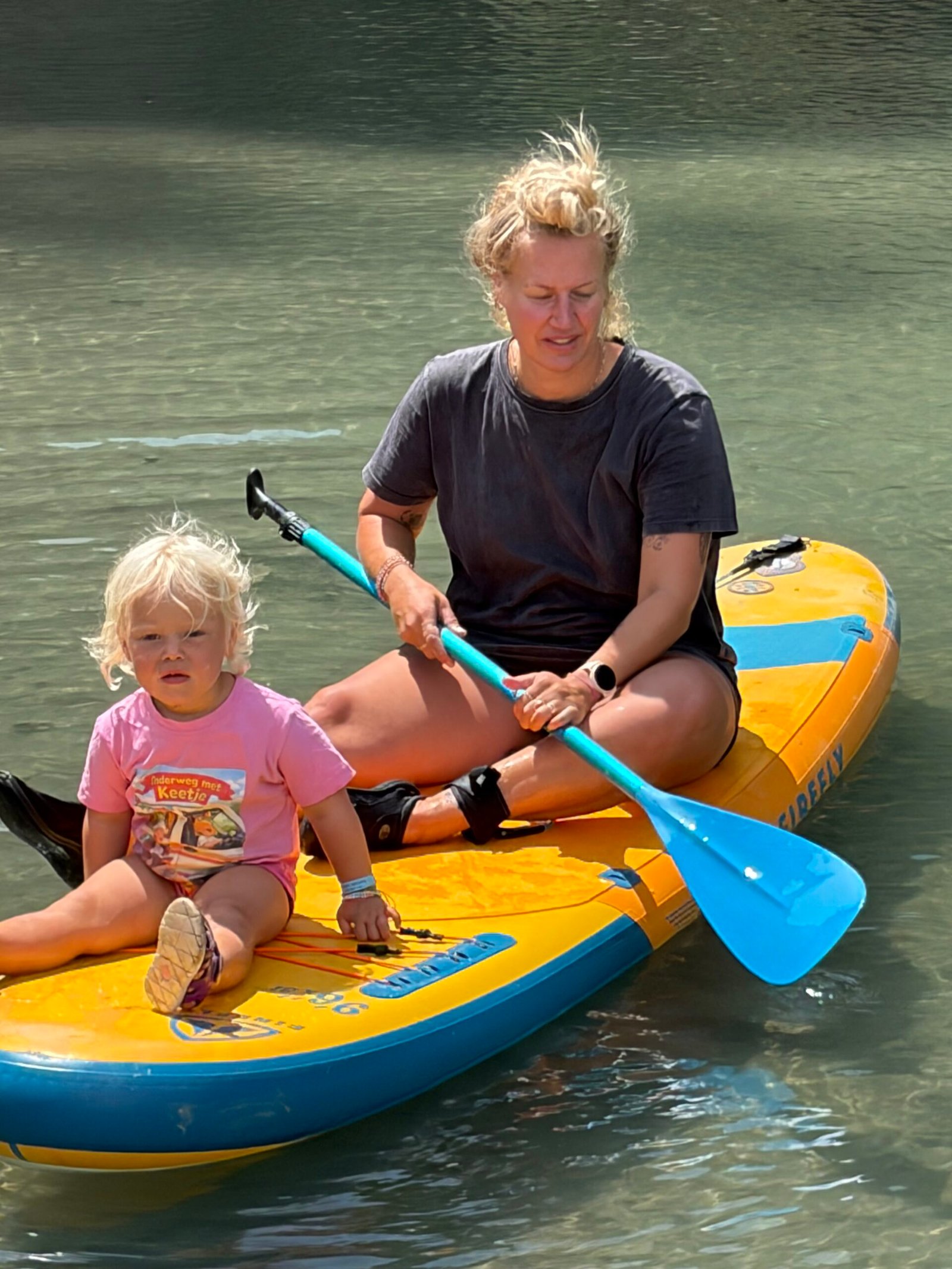 Een vrouw en een peuter zittend op een sup in de Osumi rovoer in Albanië